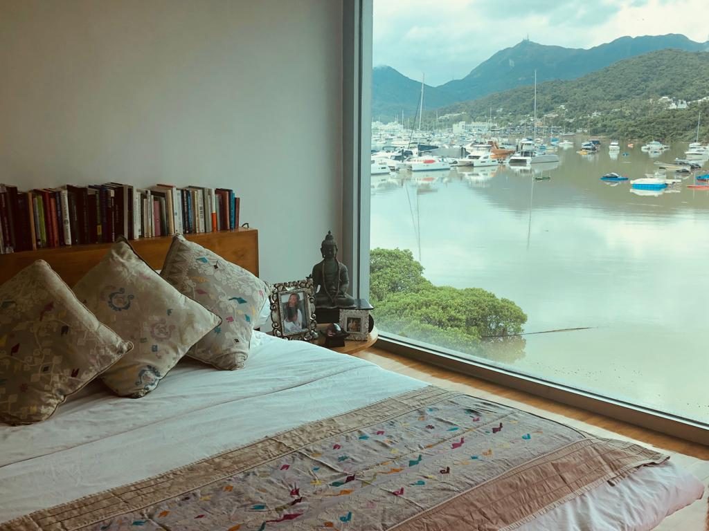 A bedroom with beautiful silk covers looking out over a Hong Kong harbour.