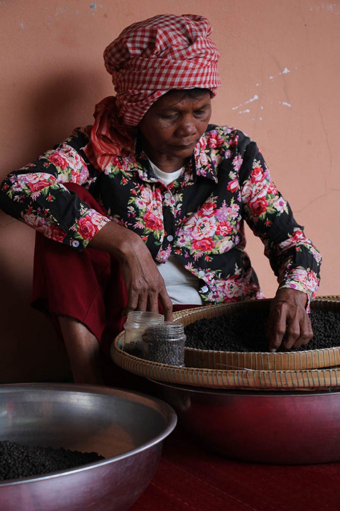 A woman preparing pepper at the Kampot pepper farm.