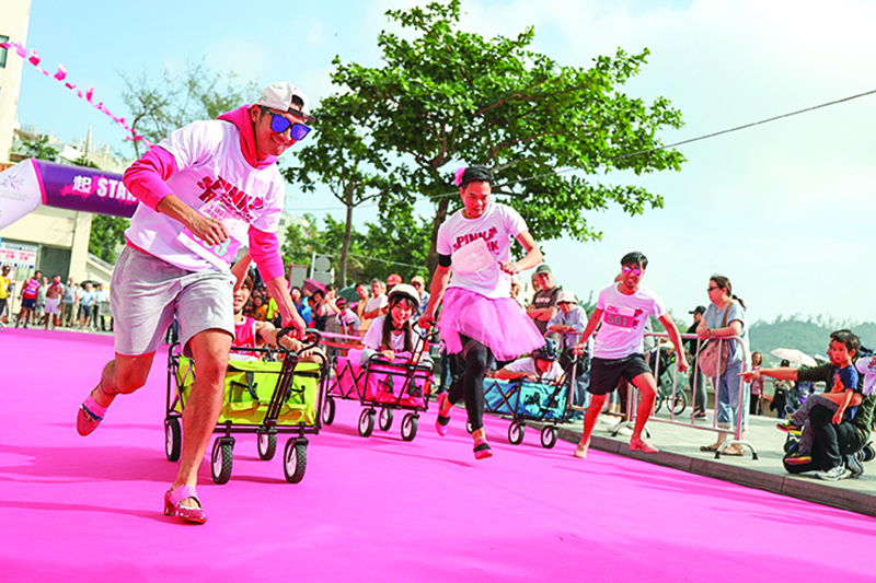 A group of men race down a pink carpet for the Pink Run wellness event in Hong Kong.