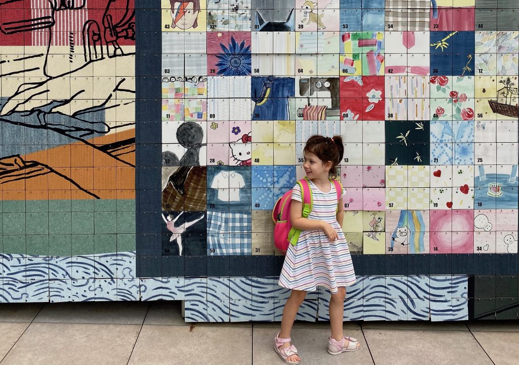 A small girl stands in front of an art installation at The Mills in Hong Kong. 