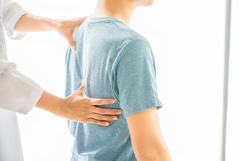 A man has his spine checked at a posture correction class at UPHealth Clinic in Hong Kong. 