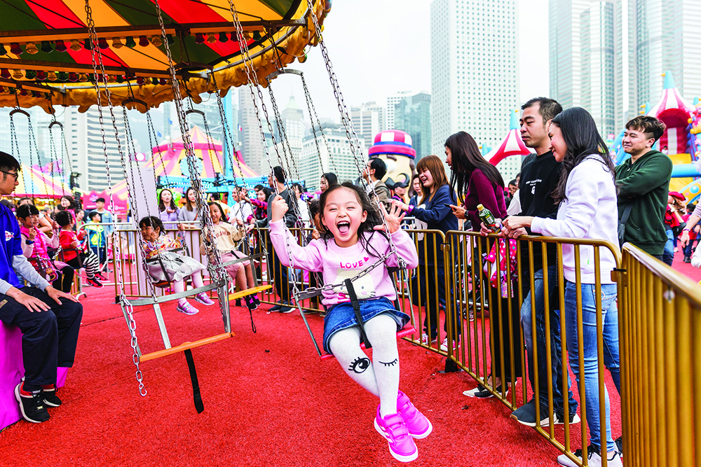 A girl on a ride at the AIA Carnival, a zero waste gift option for kids in Hong Kong.