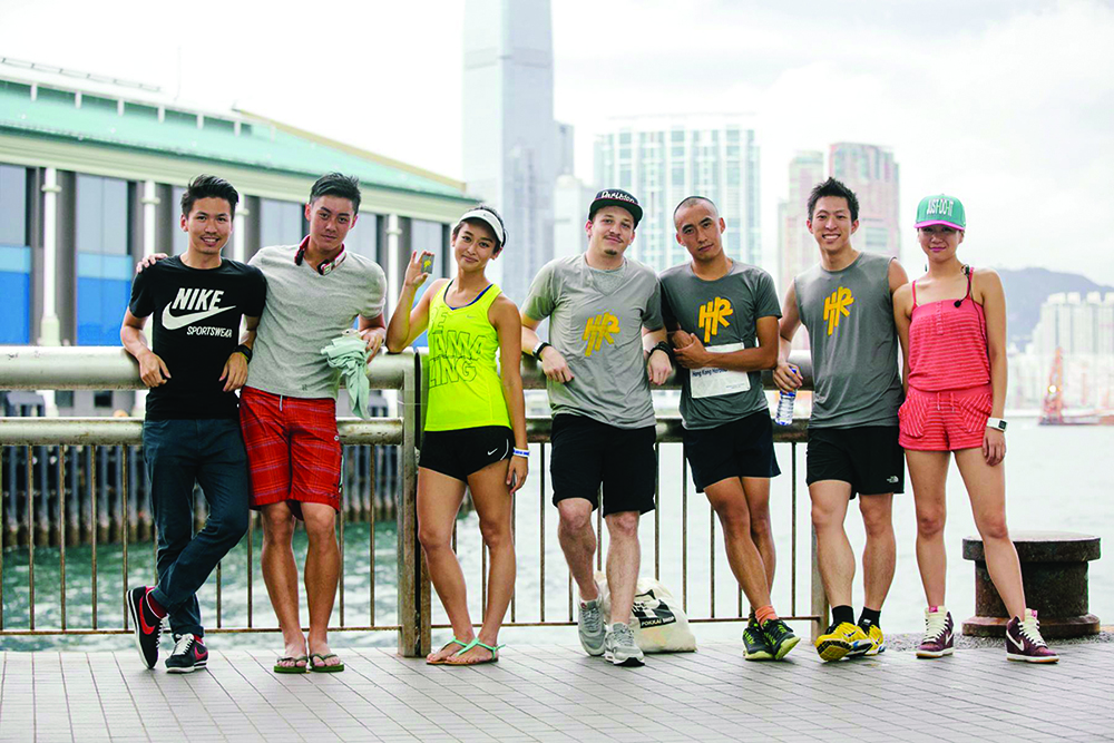 Several runners pose on Hong Kong's harbour, after a free workout class offered by Harbour Runners. 