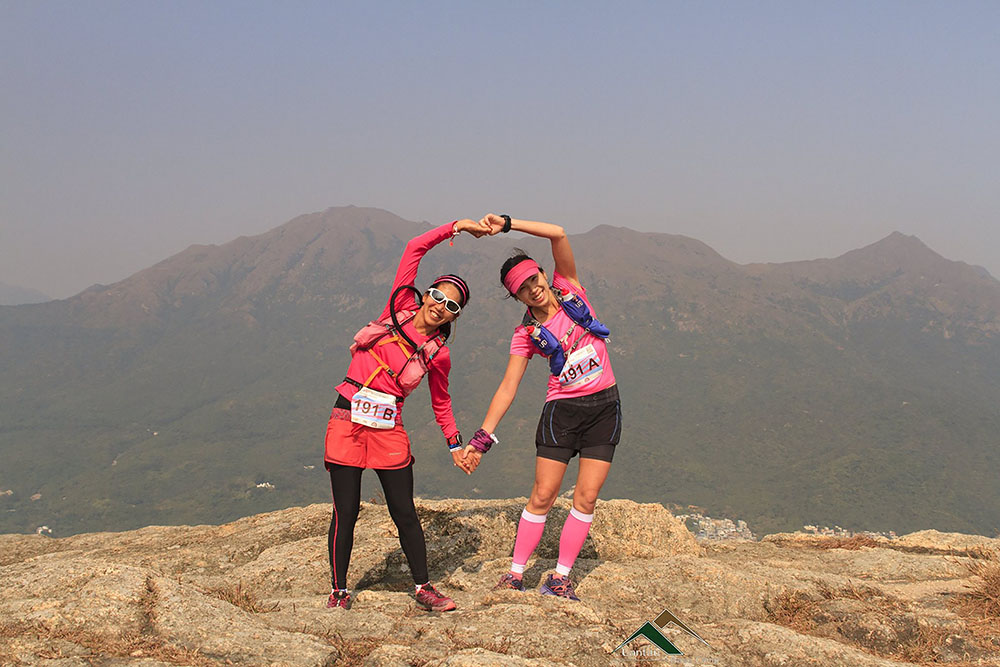 Two women make the shape of a heart on a mountain in Hong Kong during a Valentine's Day trail race, a wellness events in February. 