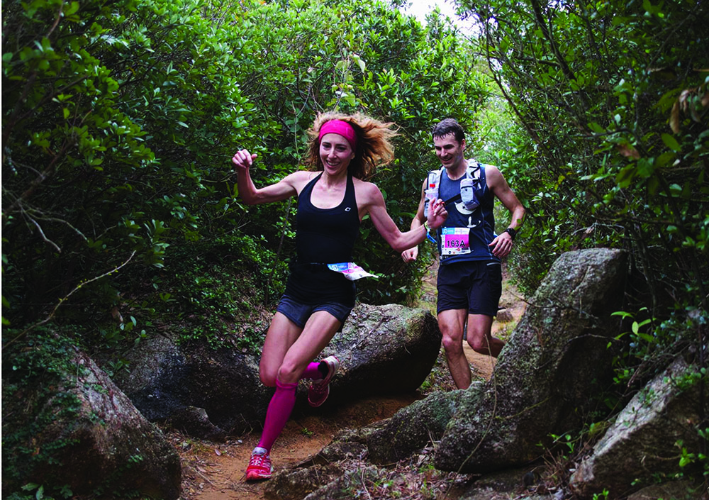 A woman and a man run on a trail during the Valentine's Day race, February wellness events in Hong Kong.