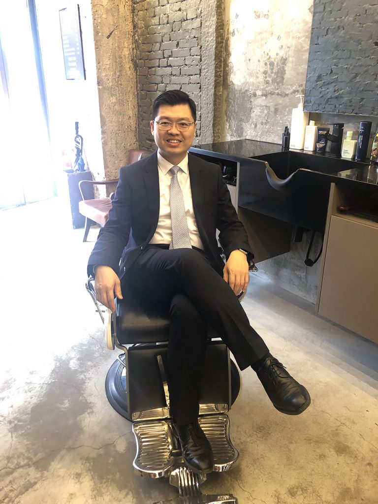 Dr. Ho Yap-lin in a barber's chair, who is a prostate cancer specialist.